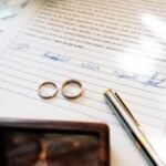 Home Elegant wedding rings laid on a signed marriage certificate, symbolizing commitment.